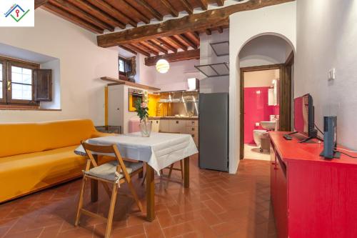 a living room with a table and a yellow couch at Casa Dei Briganti by TuscanyWeGo in Massa