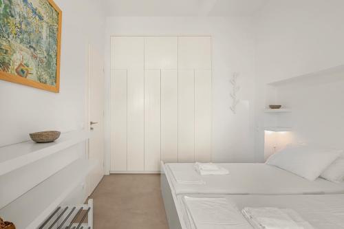 a white room with a bed and a painting at Ondalina in Kardiani