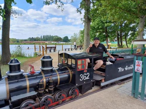 a woman sitting on a miniature train at a park at Cosy cabin for 6 in Great Billing in Great Billing