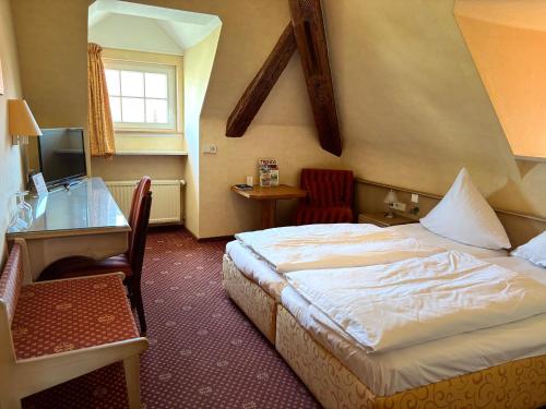 a hotel room with a bed and a desk at Gasthof Die Krone in Schwäbisch Hall