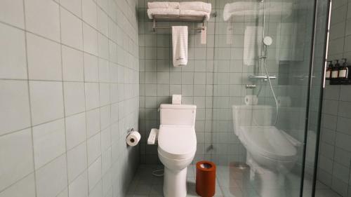 a bathroom with a toilet and a glass shower at Rodona Hotel in Mexico City