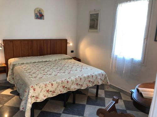 a bedroom with a bed with a floral bedspread and a window at Holiday Home Villa Bobolino in Montelupo Fiorentino
