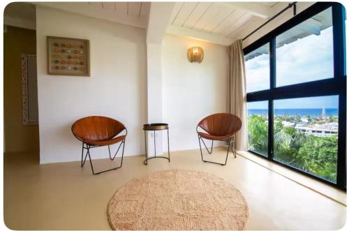 two chairs and a rug in a room with a large window at Urban Boutique Hotel in Las Terrenas
