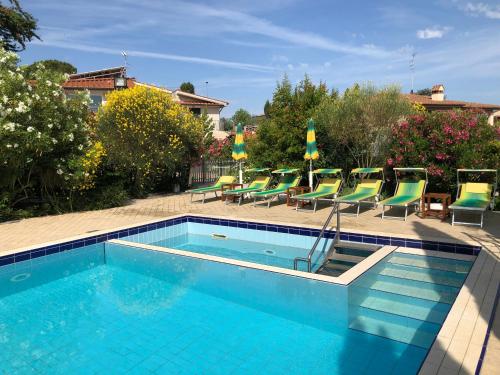 a swimming pool with chaises and chairs in a yard at Holiday Home Villa Bobolino in Montelupo Fiorentino