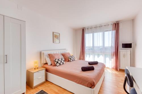 une chambre avec un lit et une grande fenêtre dans l'établissement Spacious 2BR Flat near CDG airport, au Blanc-Mesnil