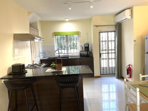 a kitchen with a counter and two bar stools at Palm Green Villa in Grand Baie