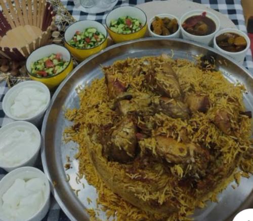 a plate of food on a table with rice and meat at Dana Gardens Hotel in Dana