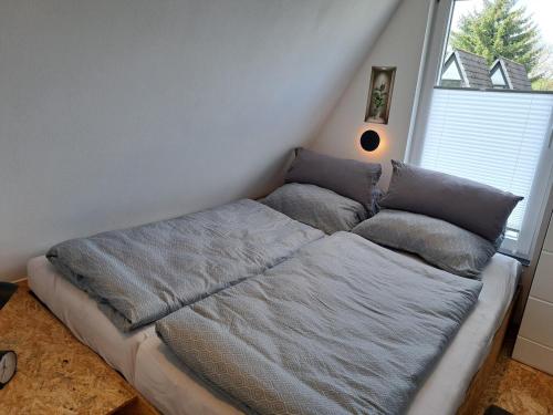 a bed with pillows on it in a bedroom at Ferienhaus Siebenschläfer mit privater Sauna in Bad Wünnenberg