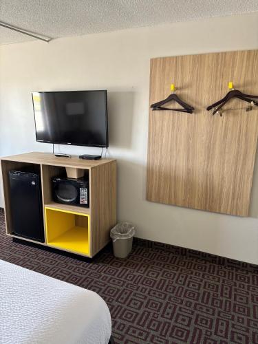 a hotel room with a flat screen tv and a bed at Days Inn by Wyndham West Branch Iowa City Area in West Branch