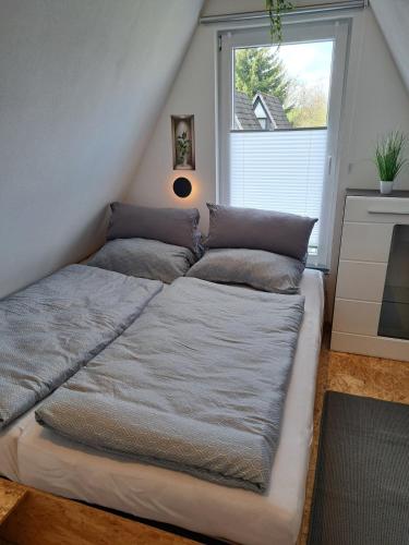 a large bed in a room with a window at Ferienhaus Siebenschläfer mit privater Sauna in Bad Wünnenberg