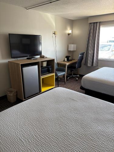 a hotel room with a bed and a flat screen tv at Days Inn by Wyndham West Branch Iowa City Area in West Branch