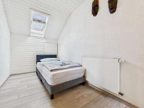 a bedroom with a bed in a white room at DG-Ferienwohnung nähe Legoland, mit großer Terrasse in Sontheim an der Brenz