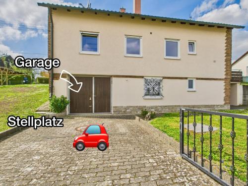 a small red car parked in front of a house at DG-Ferienwohnung nähe Legoland, mit großer Terrasse in Sontheim an der Brenz
