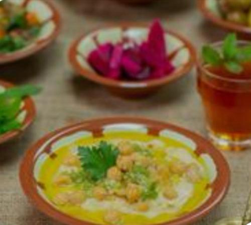 a table with plates of food and bowls of vegetables at Dana Gardens Hotel in Dana