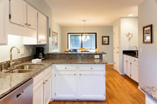Una cocina con gabinetes blancos y una ventana grande. en Racquet Club 10 by Wild Dunes, in Resort Core, en Isle of Palms