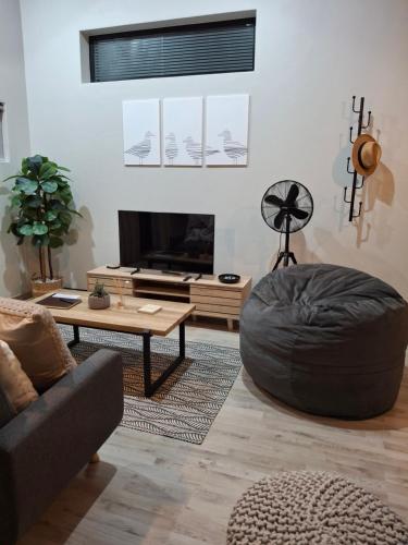 a living room with a couch and a table at Nature's Nest in Bettyʼs Bay