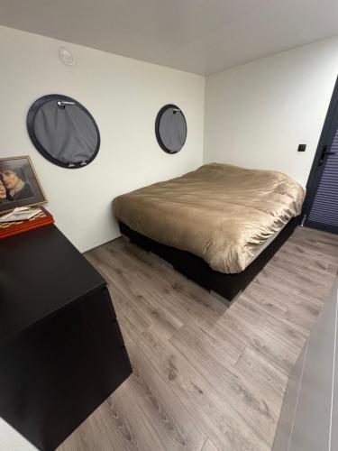 a bedroom with a bed and two mirrors on the wall at Exclusieve Houseboat La Mare 12 x 5 meter met sauna en hottup in Maasbommel