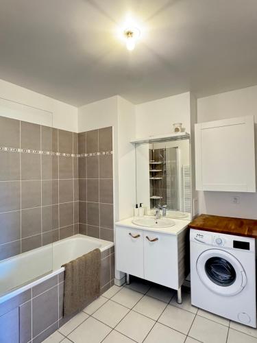 ein Badezimmer mit einem Waschbecken und einer Waschmaschine in der Unterkunft Charmant appartement aux portes de Paris, avec Balcon et Parking in Aubervilliers