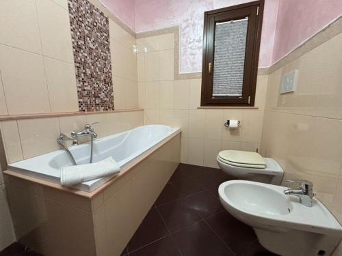 a bathroom with a tub and a toilet and a sink at Da Pupa, apartment with a sea view in Vico Equense