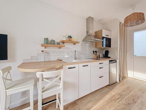 een keuken met witte kasten en een aanrechtblad bij Charmant studio Bernerie-en-Retz in La Bernerie-en-Retz