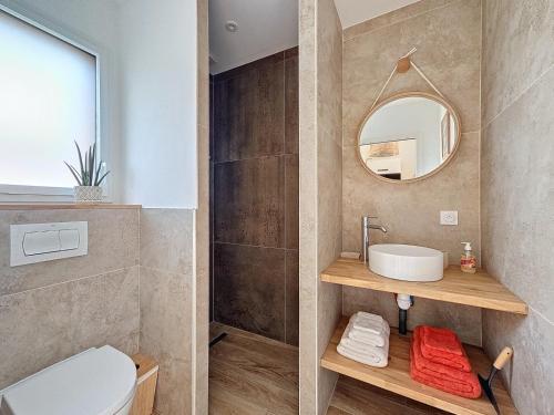 een badkamer met een toilet, een wastafel en een spiegel bij Charmant studio Bernerie-en-Retz in La Bernerie-en-Retz