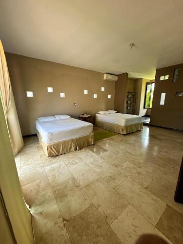 a bedroom with two beds and a tiled floor at Pool and Jacuzzi Beachfront house CostaAzul ElSalvador in Acajutla