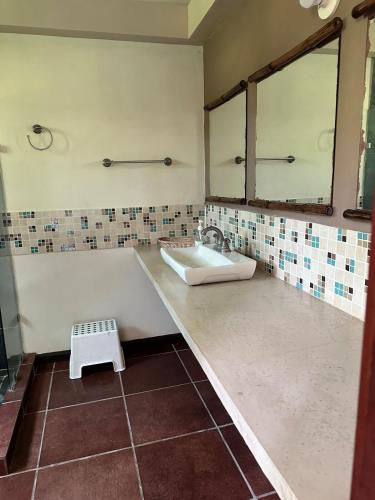 a bathroom with a sink and a mirror at Pool and Jacuzzi Beachfront house CostaAzul ElSalvador in Acajutla