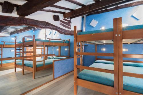 two bunk beds in a room with blue walls at Albergue Cuatro Cantones (Exclusivo para Peregrinos) in Belorado