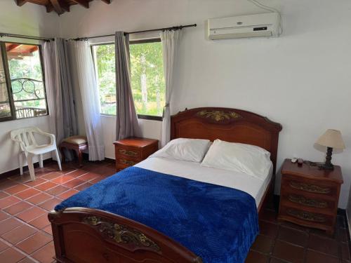 a bedroom with a bed with a blue blanket at Hotel El Danubio Campestre in Cartago