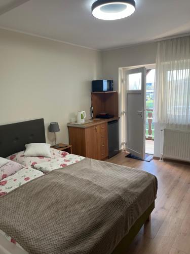 ein Schlafzimmer mit großem Bett und eine Küche in der Unterkunft Pokoje gościnne Antonia in Władysławowo