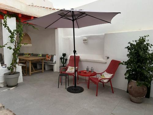a patio with a table and chairs and an umbrella at Lemon House in Vélez-Málaga