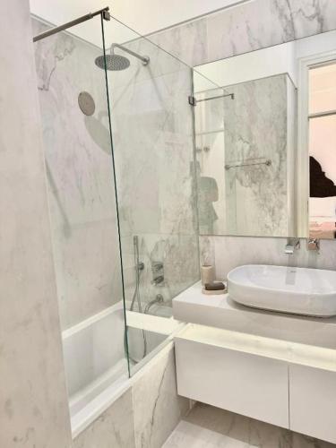 un bagno bianco con lavandino e doccia di Quarto Com Banheiro no Coração de Lisboa a Lisbona