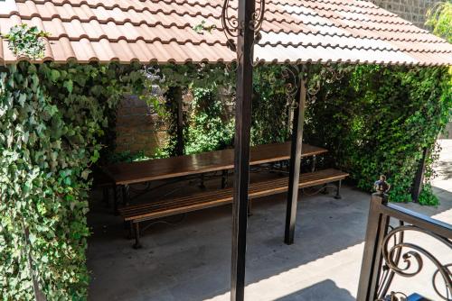 a wooden bench under an umbrella on a patio at Villa Musaler in Musalerr