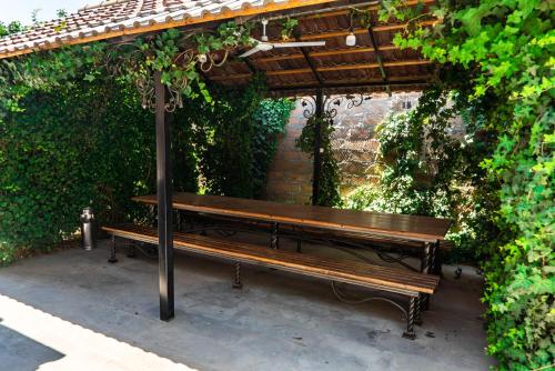 a wooden bench sitting under a pergola at Villa Musaler in Musalerr