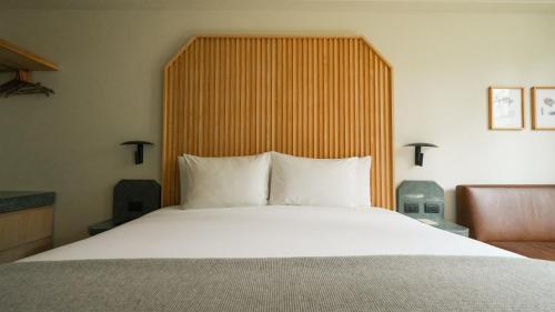 a bedroom with a large bed with a wooden headboard at Rodona Hotel in Mexico City