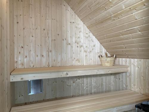 a wooden wall with a shelf in a sauna at Am Dahmer Leuchtturm 23f in Dahme