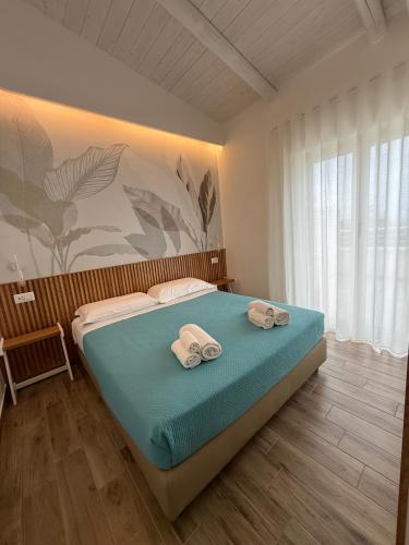 a bedroom with a bed with two towels on it at SUNSEA - Enjoy Your Family in Capo Vaticano