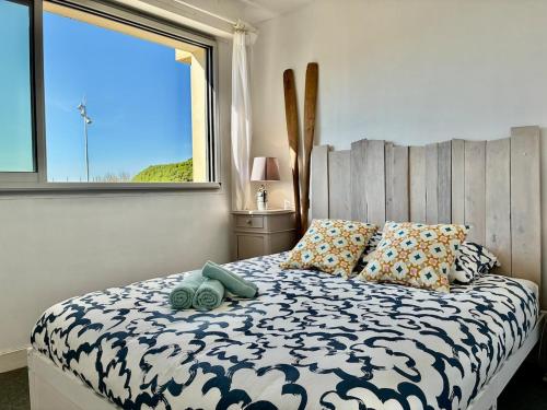 une chambre avec un lit avec des oreillers et une fenêtre dans l'établissement Ocean SPOT, Vue sur la mer, Vacance Famille, Parking, Surf, 4P, à Hossegor