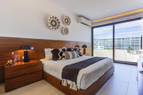 a bedroom with a large bed and a large window at Aria Ocean Condominios in Nuevo Vallarta 