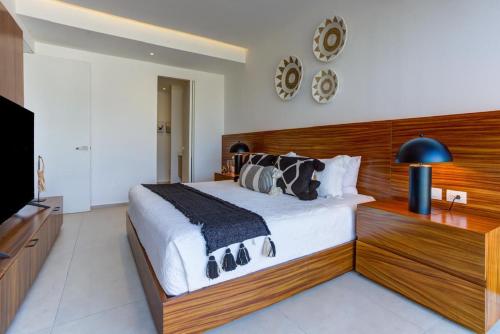 a bedroom with a large bed and a flat screen tv at Aria Ocean Condominios in Nuevo Vallarta 