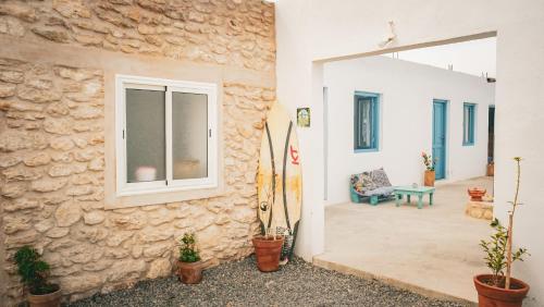 a house with a stone wall and a patio at IBI Surf House in Sidi Kaouki