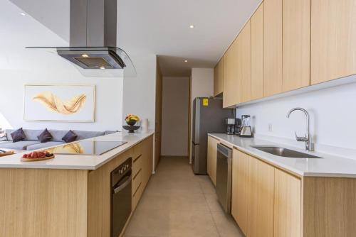 a kitchen with wooden cabinets and a stainless steel refrigerator at Aria Ocean Condominios in Nuevo Vallarta 