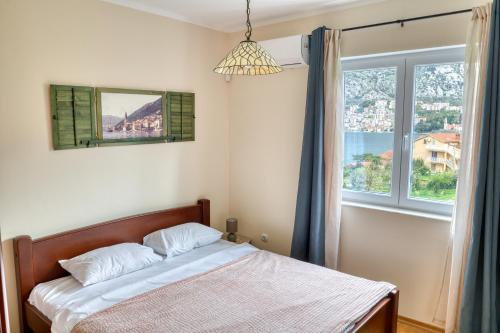a bedroom with a bed and a window at Beautiful Apt Anna with Sea View by MN Property in Kotor
