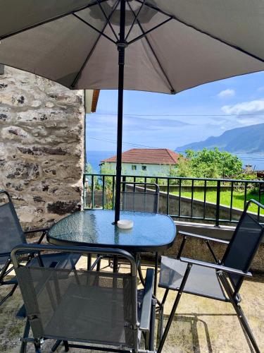 a table and chairs with an umbrella on a balcony at Amélia's House in Seixal