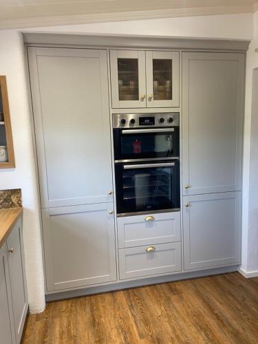 a kitchen with a white cabinet with two ovens at Farm Stay at THE GLEBE COTTAGE KILREA in Tamlaght