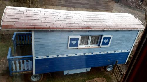 a blue house with two windows and a roof at Charming Caravan Near Hamois with Garden in Chevenia