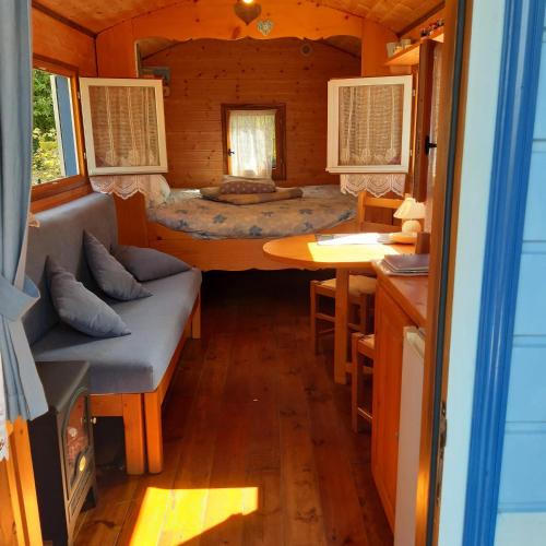a room with a bed and a table in a cabin at Charming Caravan Near Hamois with Garden in Chevenia