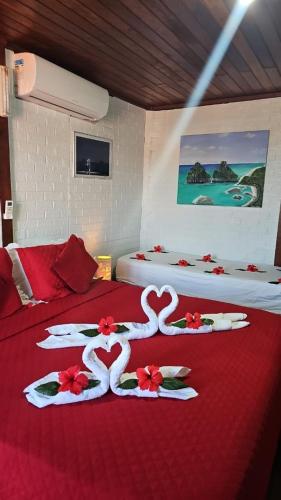 two beds with red and white decorations on them at Pousada Capim Açu in Fernando de Noronha