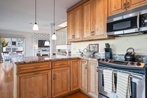 a kitchen with wooden cabinets and a stove top oven at Waterfront Getaway - Dock UR Boat & Walk to Beach in Annapolis