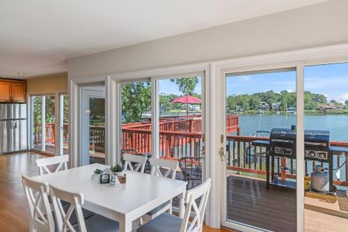 a living room with a white table and chairs and a balcony at Waterfront Getaway - Dock UR Boat & Walk to Beach in Annapolis